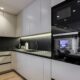 Modern kitchen design with handleless cabinets, black countertop, and backdrop. Includes LED underglow.